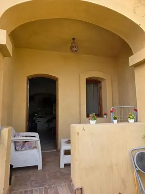 a kitchen with an archway and a table and chairs at Westgolf Y62 in Hurghada