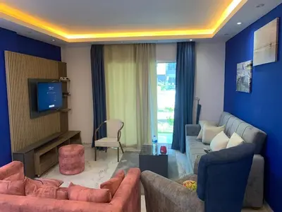 a living room with two couches and a tv at Elegant 3BR Luxury Suite - Fanadir Bay in Hurghada