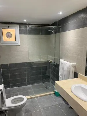 a bathroom with a shower and a toilet and a sink at Elegant 3BR Luxury Suite - Fanadir Bay in Hurghada