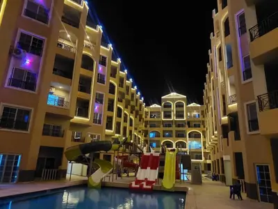 a swimming pool with a slide in front of a building at Juliana beach resort in El Gouna