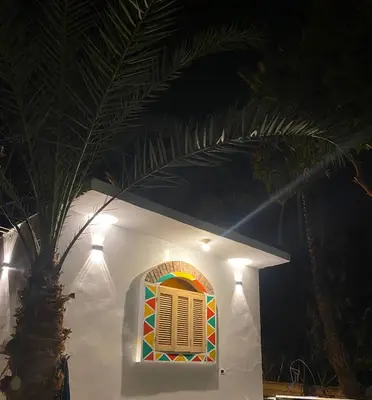 a colorful window on a white house with lights at Rooma ka Guest House in Aswan