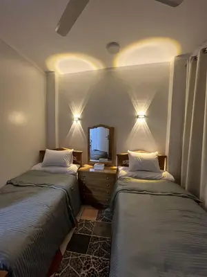a room with two beds and a television in it at Dahabiya Apartment in Luxor