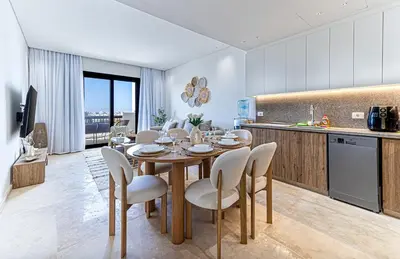 a kitchen and dining room with a table and chairs at Stylishly furnished and quietly located apartment in Hurghada