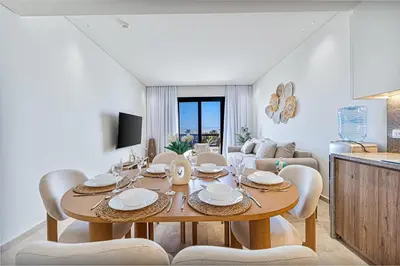 a dining room with a wooden table and chairs at Stylishly furnished and quietly located apartment in Hurghada