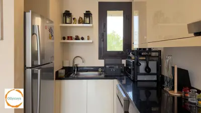 a kitchen with white cabinets and a stainless steel refrigerator at Ancient Sands 4BR Villa Heated pool in El Gouna