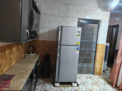a kitchen with a white refrigerator in a room at روف كناريا in Luxor