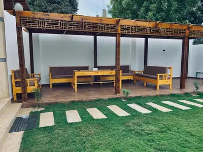 a wooden gazebo with benches and a table at Farah Hotel in Al Aqālitah