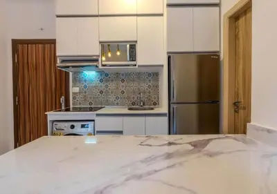 a kitchen with white cabinets and a stainless steel refrigerator at Luxury One-Bedroom Apartment Near El Gouna in Hurghada