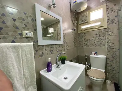 a bathroom with a sink and a toilet and a mirror at Star Beach 3BR in Hurghada