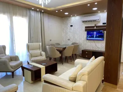 a living room with a couch and a table and a television at Star Beach 3BR in Hurghada