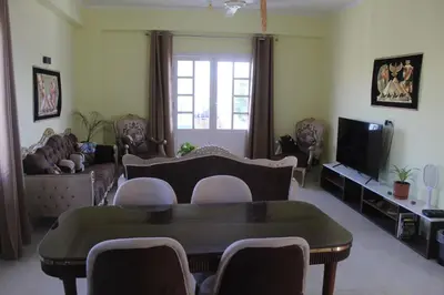a living room with a table and chairs and a tv at Villa-Djorf Westbank in Al Aqālitah