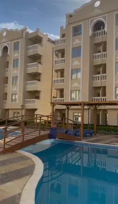 a hotel with a swimming pool in front of a building at Stylish home & Free transfers in Hurghada