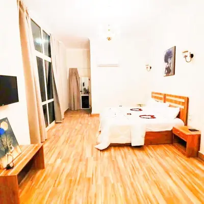 a bedroom with a white bed and a wooden floor at VIP hotel & café in Qilfāw