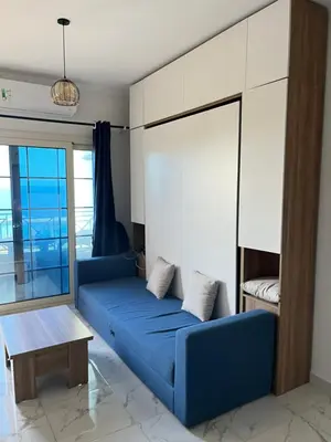 a living room with a blue couch and a table at Juliana Beach Resort, Hurghada in Hurghada