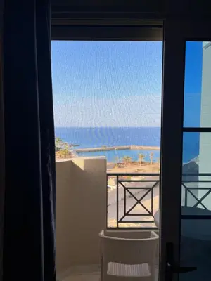 a room with a view of the ocean from a balcony at Juliana Beach Resort, Hurghada in Hurghada