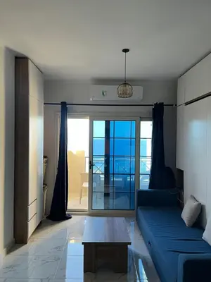 a living room with a blue couch and a table at Juliana Beach Resort, Hurghada in Hurghada