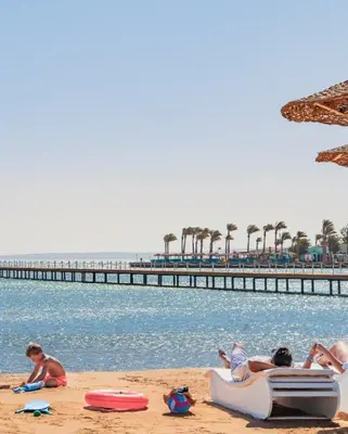 a group of people laying on the beach near the water at Holiday Seaview Home I Near Palacio Hotel I WIFI in Hurghada
