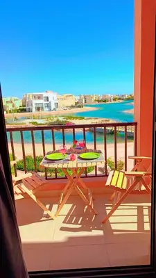 a table and chairs on a balcony with a view of the beach at Yoke 2 bedrooms Duplex Tawila ElGouna, Plaza gouna in Hurghada