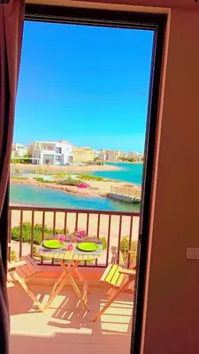 a view of a balcony with a table and the ocean at Yoke 2 bedrooms Duplex Tawila ElGouna, Plaza gouna in Hurghada