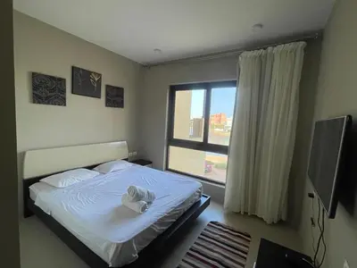 a bedroom with a white bed and a window at Lovely 1 bd apartment with amazing view in Tawila in Hurghada