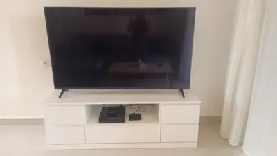 a flat screen tv sitting on a white entertainment center at Lovely 1 bd apartment with amazing view in Tawila in Hurghada