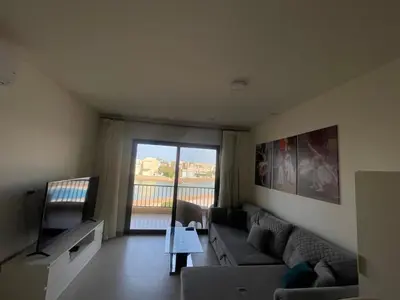 a living room with a couch and a tv at Lovely 1 bd apartment with amazing view in Tawila in Hurghada
