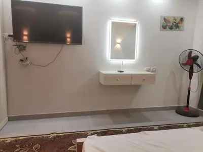 a white room with a flat screen tv on the wall at Modern Downtown Apartment In Scandic Resort WiFi Beach Front in Hurghada