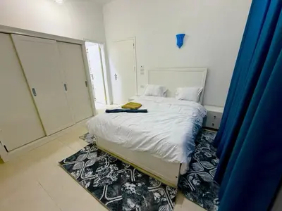 a bedroom with a bed with white sheets and a rug at Secrets Of The Nile in Luxor