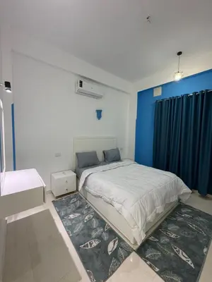 a bedroom with a large bed with a blue wall at Secrets Of The Nile in Luxor
