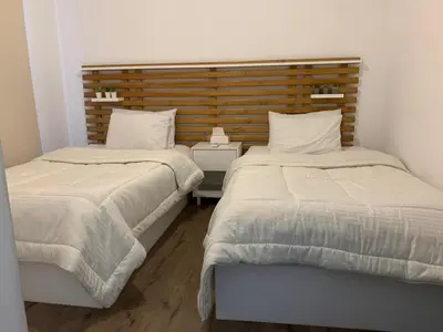 two beds sitting next to each other in a bedroom at 2bd direct on the main pool in Hurghada