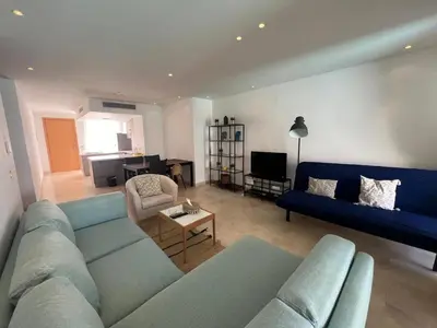 a living room with a blue couch and a table at 2bd direct on the pool in Scarab El Gouna in Hurghada