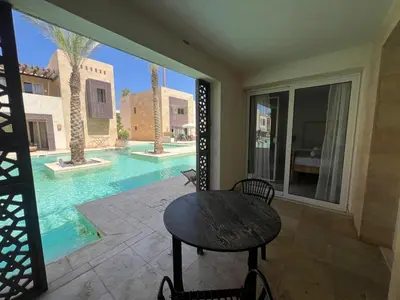 a patio with a table and a swimming pool at 2bd direct on the pool in Scarab El Gouna in Hurghada