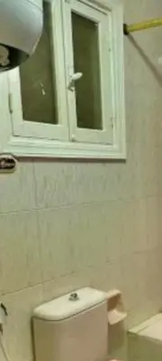 a bathroom with a toilet with a window and a sink at Apartment for daily rent free beach access in Hurghada