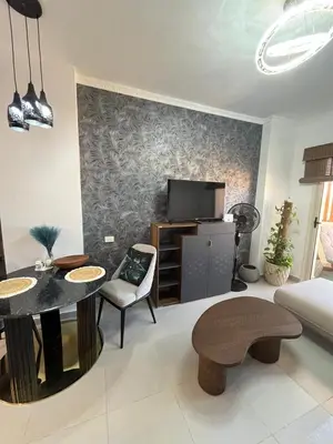 a living room with a table and a tv at Benashti Hurghada apartment in Hurghada