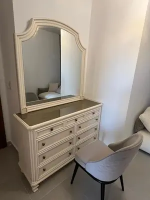 a dressing table with a mirror and a chair at Benashti Hurghada apartment in Hurghada