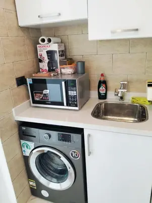 a kitchen with a microwave and a washing machine at Appartement hurghada gravity beach in Hurghada