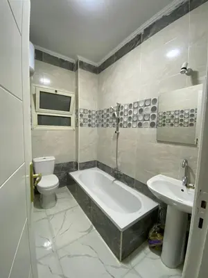 a bathroom with a tub and a toilet and a sink at الكوثر in Hurghada