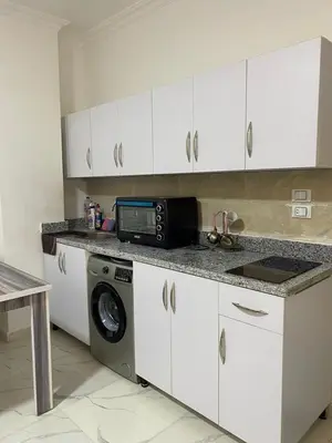 a kitchen with a washing machine and a microwave at الكوثر in Hurghada