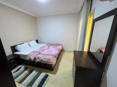 a small bedroom with a bed and a mirror at 2 bedroom furnished apartment in Hurghada