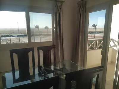 a dining room with a glass table and two chairs at Arietta Flat Amazing location in Avrio compound in Hurghada