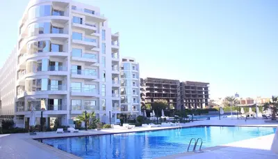 a large apartment building with a swimming pool in front of it at Scandic Resort in Hurghada