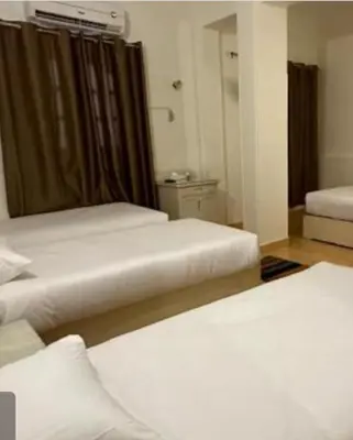 a room with two beds and a mirror at Family Hotel Luxor in Luxor