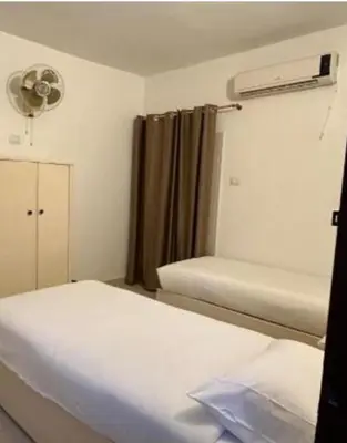a small room with two beds and a window at Family Hotel Luxor in Luxor