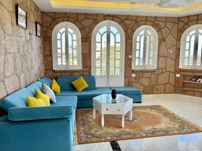 a living room with a blue couch and a table at Nile Palace Villa in Luxor