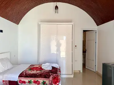 a bedroom with a bed in a room with an archway at Nile Palace Villa in Luxor