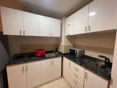 a kitchen with white cabinets and a sink and a microwave at Mark one bedroom sea view in Hurghada