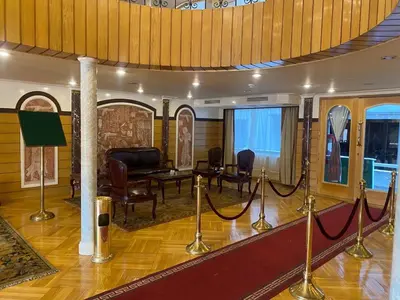 a living room with a table and chairs and a room with ropes at tarot and tamr and sun rise nile cruises in Luxor