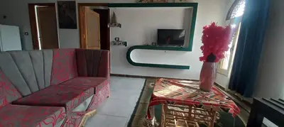 a living room with a red couch and a table at Apartment with Balcony in Luxor