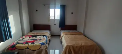 a room with two beds in it with a window at Apartment with Balcony in Luxor