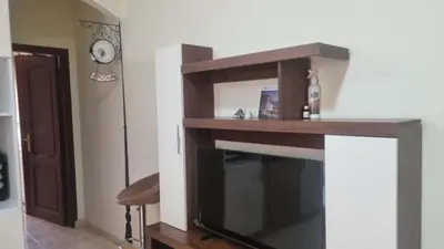 a living room with a tv and a clock at Barbara Hurghada in Hurghada